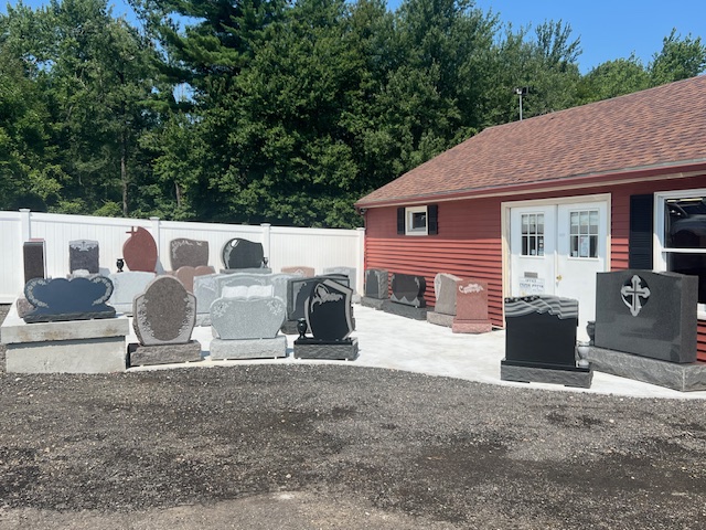 Memorials of all shapes and sizes in a yard outside a red and white building