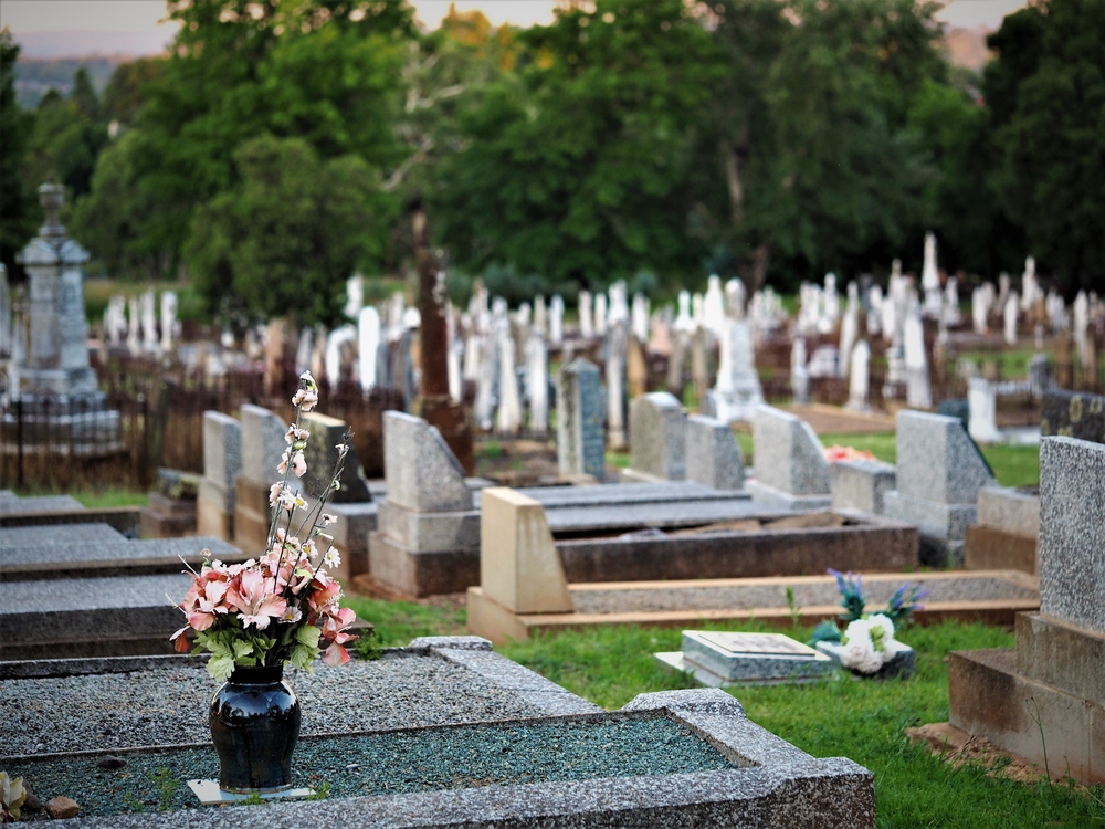 Gravestones and memorials in a green, grassy cemetary